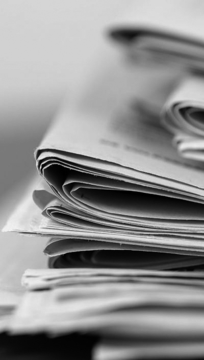 closeup-shot-several-newspapers-stacked-top-each-other-scaled-e1634292319250_grau